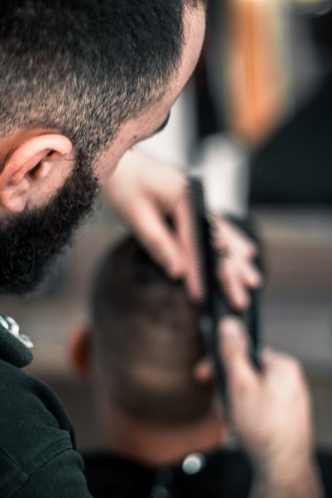 Close-up of a barber meticulously cutting a man's hair, focus on detail.
